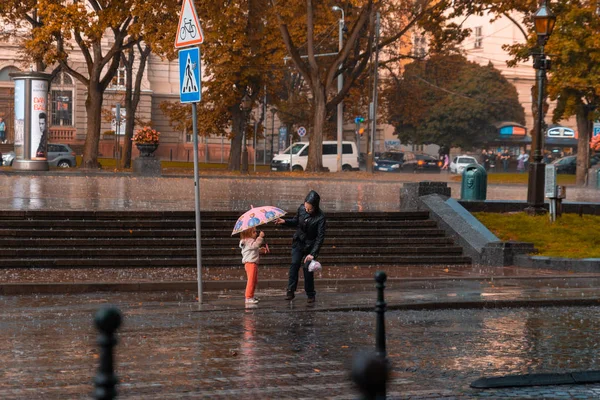 Λβιβ, Ουκρανία - 7 Σεπτεμβρίου 2018: μητέρα με μικρή κόρη υπό βροχή. παιδί με μικρή ομπρέλα — Φωτογραφία Αρχείου