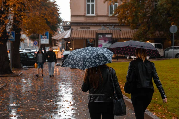 Lviv, Ukrajna - 2018. szeptember 7.: eső városban. emberek gyaloglás esernyő — Stock Fotó