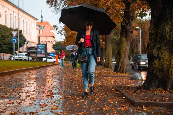Молодая Женщина Ходит Черным Зонтиком Дождем Желтые Листья Земле Приближается — стоковое фото
