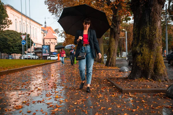 Giovane Donna Camminare Con Ombrello Nero Sotto Pioggia Foglie Gialle — Foto Stock