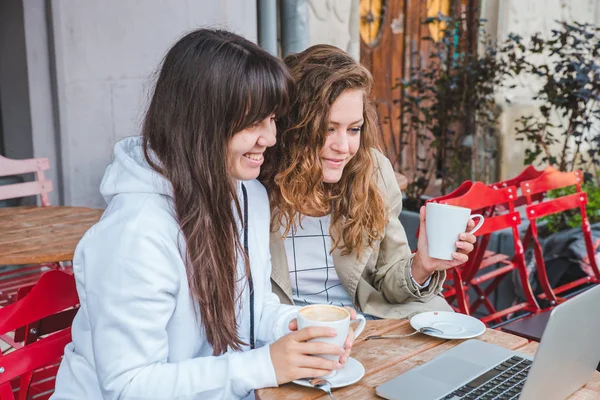 Две Взрослые Девушки Пьют Кофе Смотрят Ноутбук Кафе Открытом Воздухе — стоковое фото