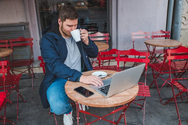 Ung Vuxen Man Arbetar Laptop Utomhus Café Med Kopp Latte — Stockfoto