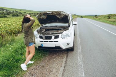 karayolu üzerinde kırık araba yakın duran ve Evet Genç Yetişkin kadın. Arama araba servisi