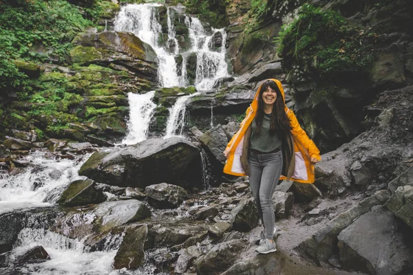 Жінка Стоїть Жовтому Плащі Дивиться Водоспад Концепція Пішохідного Туризму — стокове фото