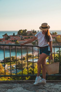 günbatımı üzerinde yürüyen Genç Yetişkin kadın. Sveti stefan Adası arka plan üzerinde. yaz tatili