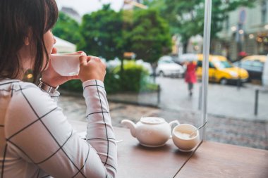büyük cam pencere ve güzel manzaralı şehir sokak kafede oturan kadın. yaşam tarzı