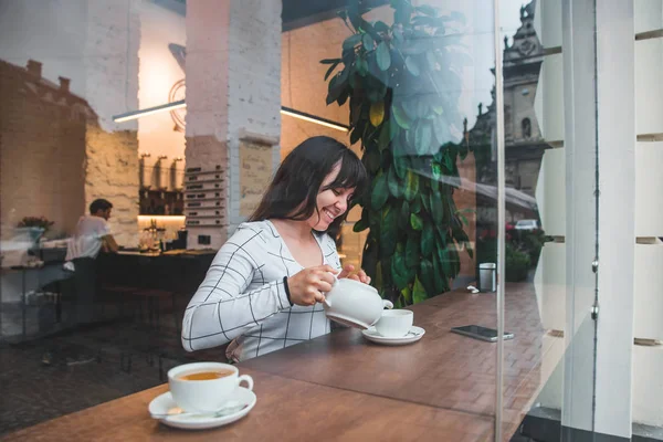 Женщина Наливает Чай Чашку Кафе Вид Через Стеклянное Окно — стоковое фото