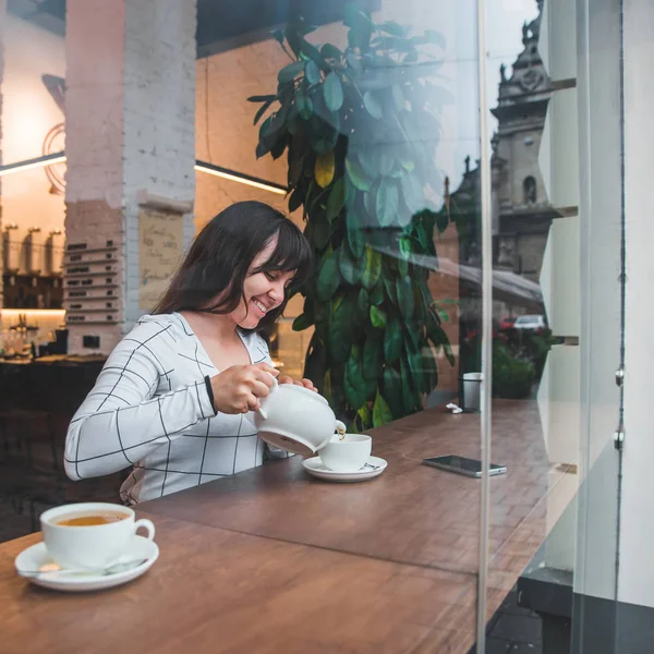 Женщина Наливает Чай Чашку Кафе Вид Через Стеклянное Окно — стоковое фото