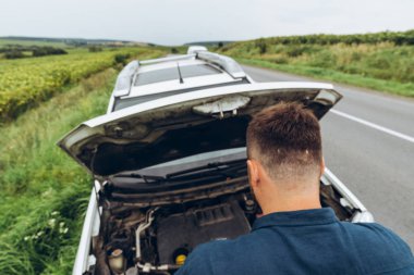 yol kenarında, kırık araba motoru bakarak adam. Road trip sorunları