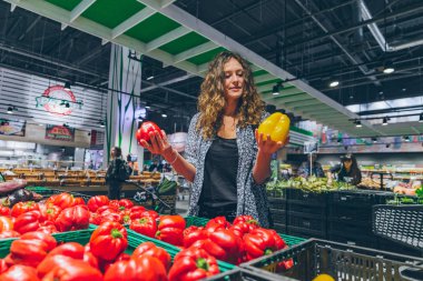 Genç kadın markette salata kağıt seçimi oldukça. kopya alanı