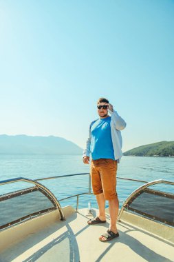 burun arka plan üzerinde deniz ve dağlar ile teknenin, ayakta başarı adam. yaz tatili