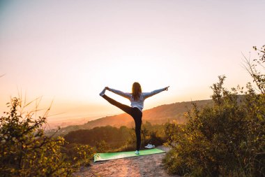 kadın yapma egzersiz gündoğumu üstünde belgili tanımlık tepe üzerinde. sağlıklı yaşam tarzı.
