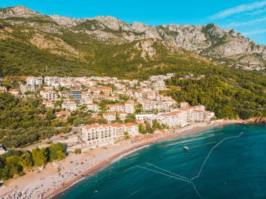 İnsanlar akşam zamanında deniz kenarında güneşlenirken hava görünümünü. yaz tatili