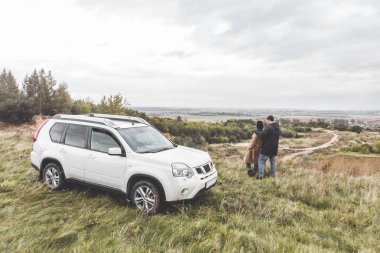 tepenin üstünde ayakta suv araba ile birkaç. bulutlu hava