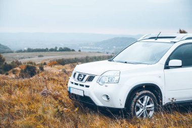 SUV otomobil sonbahar yağmurlu havalarda tepenin üstündeki