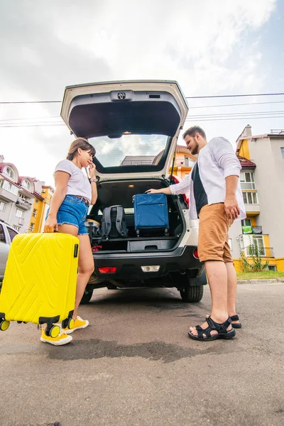 couple packing bags in car trunk. road trip. car travel