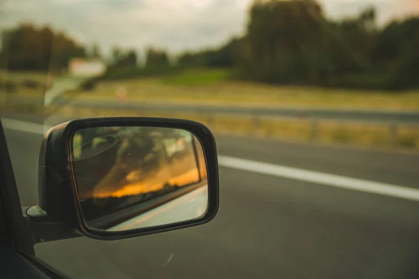 高速道路上の車。車のミラーの反射の夕日 — ストック写真