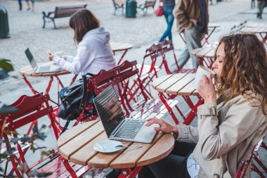 kafede farklı masada oturan iki kadın. latte içmek. dizüstü bilgisayar üzerinde çalışıyor. yaşam tarzı kavramı