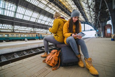 İki valiz tren istasyonunda oturmak. Tren için beklemek süre dalga köpüğü enterne. seyahat kavramı