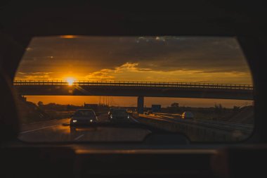 arka araba penceresinden günbatımı karayolu üzerinde görüntüleyin. araba yolculuğu