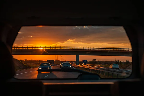 Θέα Από Παράθυρο Του Πίσω Αυτοκινήτου Ηλιοβασίλεμα Στον Αυτοκινητόδρομο Οδικό — Φωτογραφία Αρχείου