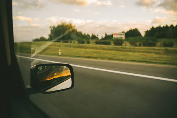 Αυτοκίνητο Στον Αυτοκινητόδρομο Ηλιοβασίλεμα Στην Αντανάκλαση Καθρέφτη Αυτοκινήτου Οδικό Ταξίδι — Φωτογραφία Αρχείου