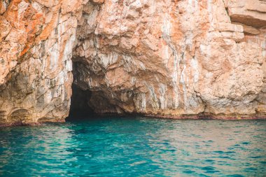 masmavi su ile kayalık uçurum mağara görünümünü