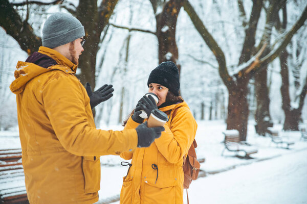 пара, гуляющая по снежному городскому парку и общающаяся. романтическое свидание зимой. Рождество грядет
