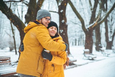 Çift kış kar yağdı parkta sarıl. kahve içme soğuk gün kavram ısınmak için