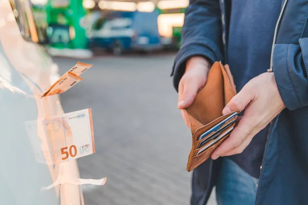 ガソリン スタンドで車 ガソリンの値上げ 男はお金の概念と空の財布を示しています — ストック写真