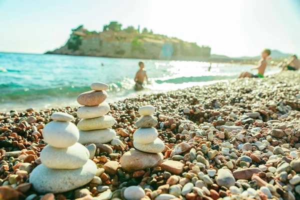 balanced rocks at seaside. rocky beach on sunset. kids swimming on background. vacation in montenegro