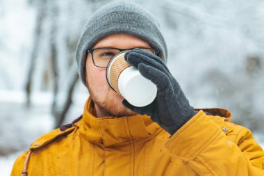 kar yağdı Şehir Parkı kavramında gitmek için kahve içme güçlü gülümseyen adam portresi
