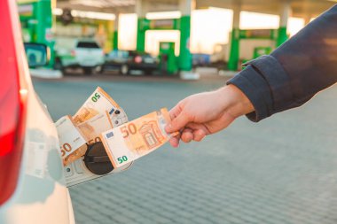 adam el araba tank için euro para koymak. benzin istasyonu kavramı