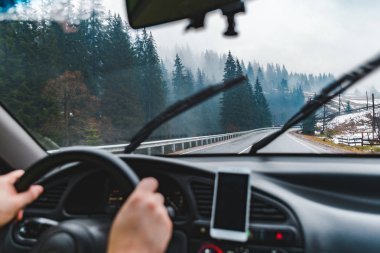 adam araba sevk tarafından kar yağdı dağlar yol. Pano navigasyon ile telefon