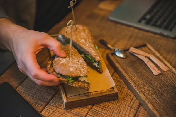 Hombre Tomando Sándwich Cafetería Trabajando Con Ordenador Portátil Cerca Concepto — Foto de Stock