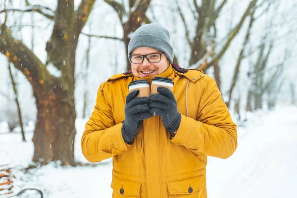 雪が降った都市公園における友人にコーヒーを持ってくる 冬のシーズン — ストック写真