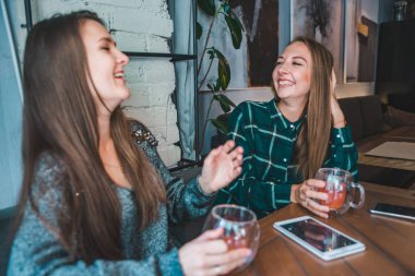 iki kız arkadaşım kafede içki ise bir çay konuşuyor. Toplantı kavramı