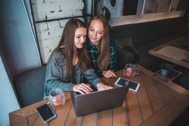 Toplantı kafede iki modern kadın. Dizüstü karınca tablet kavramı üzerinde çalışıyor