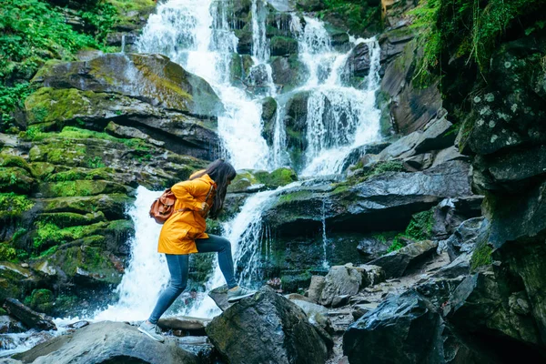 Femeia Sare Stâncă Stâncă Pădure Haină Ploaie Galbenă Apa Cade — Fotografie, imagine de stoc