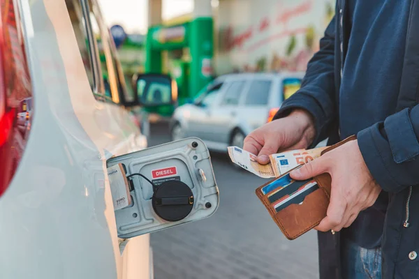 Man get euro uit de portemonnee en op tank van de auto gesteld. benzine prijsstijging. benzinestation — Stockfoto