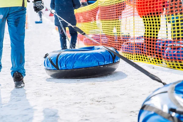 Personer i linje att rida från snow hill. snö slangar. vinter aktivitet koncept — Stockfoto