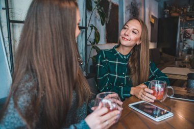 iki kız arkadaşım kafede içki ise bir çay konuşuyor. Toplantı