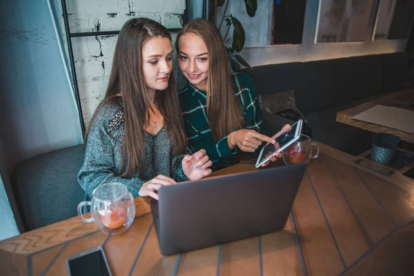 Дві сучасні жінки зустрічаються в кафе. робота на планшеті для ноутбуків — стокове фото