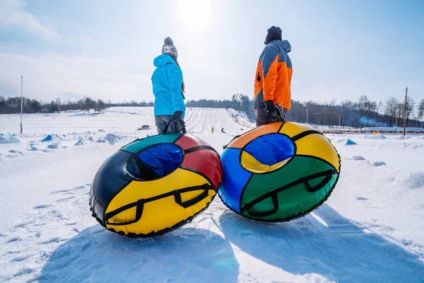 Dos Personas Tiran Trineos Cima Colina Tubo Nieve Actividad Invernal — Foto de Stock