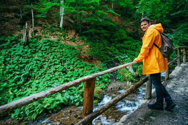 Человек Идет Лесной Тропе Водопаду Желтом Плаще Концепция Путешествия — стоковое фото
