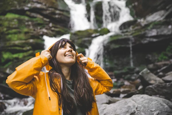 Donna Sorridente Impermeabile Giallo Con Cascata Sullo Sfondo Concetto Trekking — Foto Stock