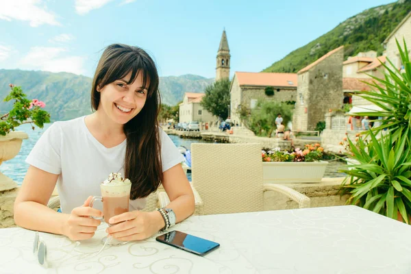 Mujer sentada en la cafetería en la costa perast en Montenegro comiendo helado — Foto de Stock