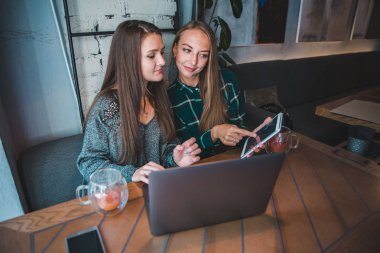 Toplantı kafede iki modern kadın. Dizüstü karınca tablet kavramı üzerinde çalışıyor