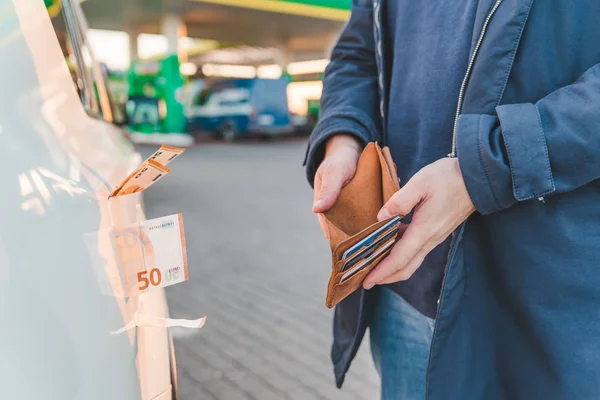 ガソリン スタンドで車 ガソリンの値上げ 男はお金の概念と空の財布を示しています — ストック写真
