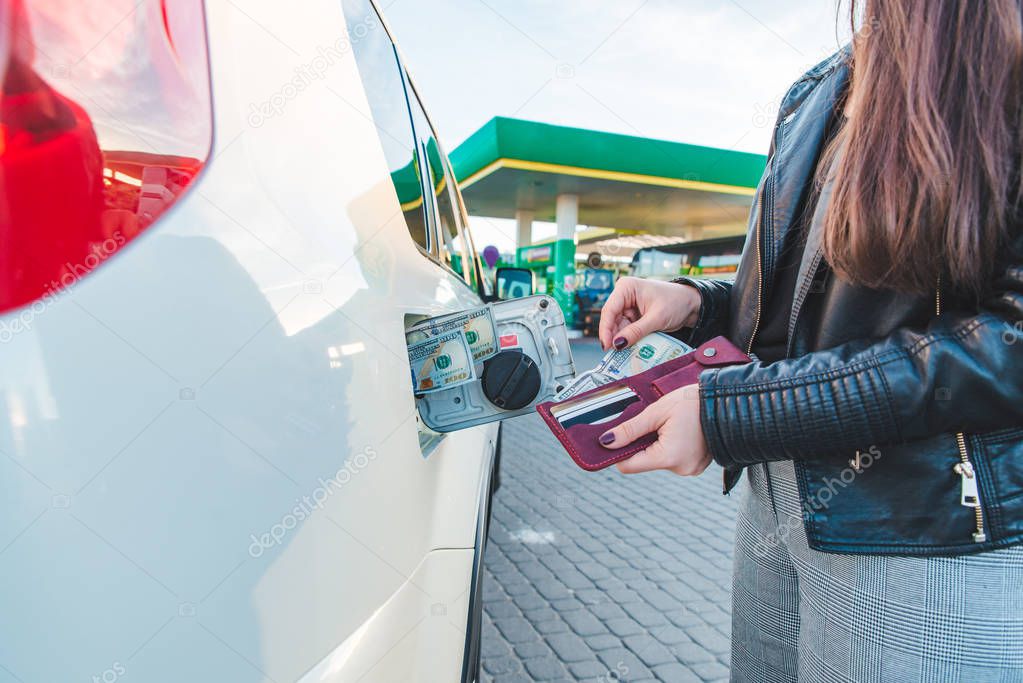 woman with wallet. put money to car tank. car fueling up concept